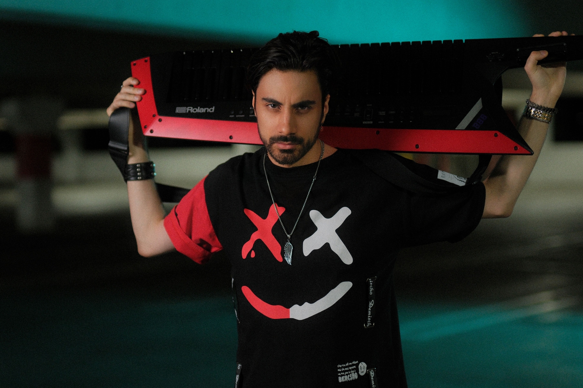 Daniel Michael holding a keytar behind him